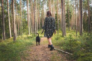 Image of girl walking her dog in a forest